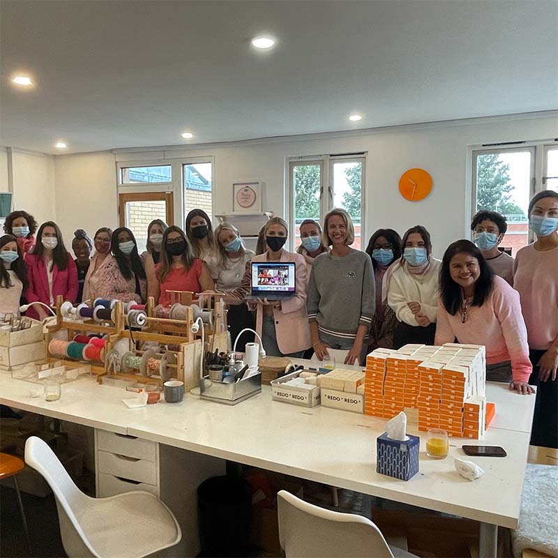 The Merci Maman UK team with Helen Addis in the London office all wearing pink.